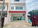 Front view of a modern townhouse with glass doors and a small gate