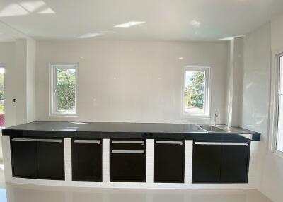 Modern kitchen with black cabinets and windows