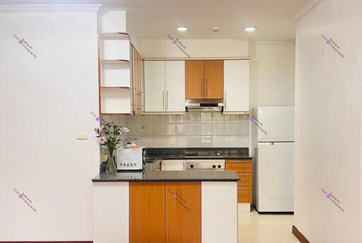 Modern kitchen with wooden cabinets, granite countertops, and appliances