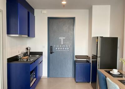 Compact modern kitchen with blue cabinets and stainless steel appliances
