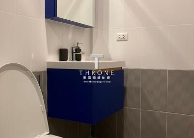 Modern bathroom with blue vanity and over-sink mirror cabinet.