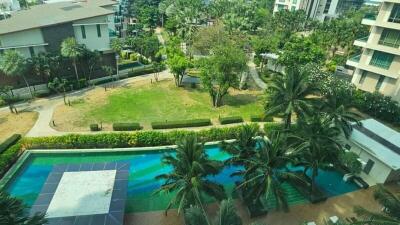 Aerial view of residential buildings with lush greenery and a swimming pool