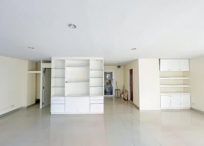 Spacious living area with built-in cabinets and shelves