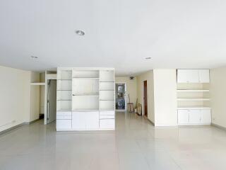 Spacious living area with built-in cabinets and shelves