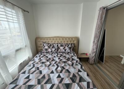 Modern bedroom with patterned bedspread and natural light