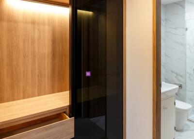 Modern hallway with built-in wooden cabinetry and access to bathroom