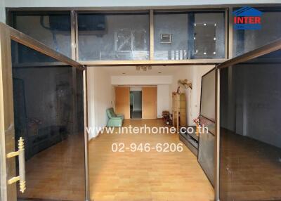 Spacious living room with wooden flooring and glass entry doors