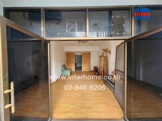 Spacious living room with wooden flooring and glass entry doors