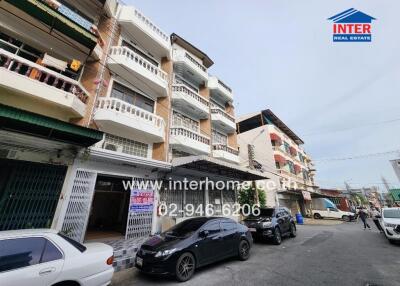 multi-story residential building with parked cars