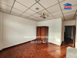 Spacious bedroom with wooden flooring and wardrobe