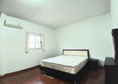 Spacious bedroom with a large bed, window, and air conditioning