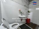 A bathroom with a toilet, sink, and red bucket