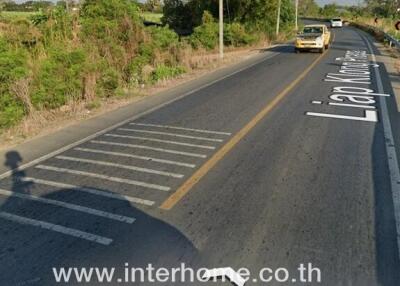 Road leading to property with visible real estate advertisement