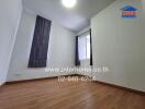 Unfurnished bedroom with large window and wooden floor
