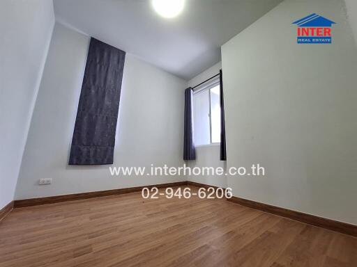 Unfurnished bedroom with large window and wooden floor