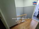 Stairwell with wooden flooring and grey walls in a property