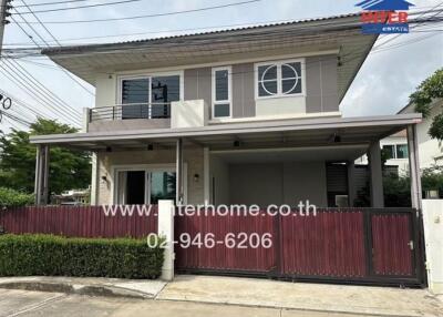 Front view of a two-story house with a modern design and gated entrance