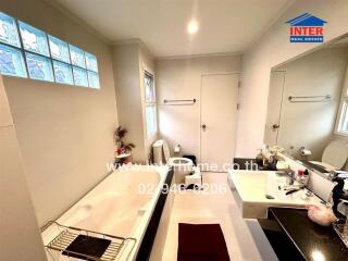 Modern bathroom with bathtub, sink, and toilet