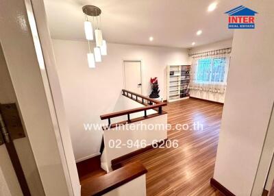 Cozy living area with wooden flooring and ample lighting