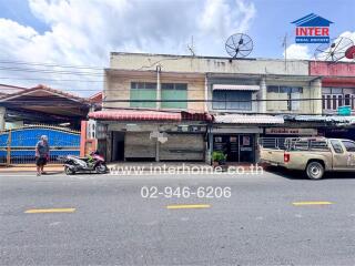 Street view of a building with commercial spaces and residential units