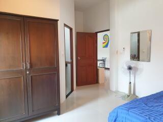 Spacious bedroom with a wardrobe, wall mirror, and access to the ensuite bathroom