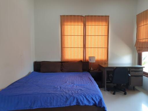 Bedroom with bed, desk, chair, and windows with blinds