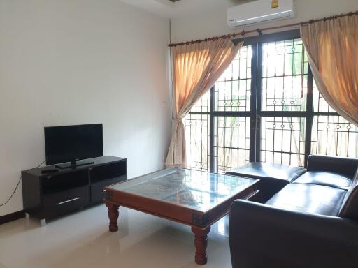 Well-lit living room with modern furniture and large windows