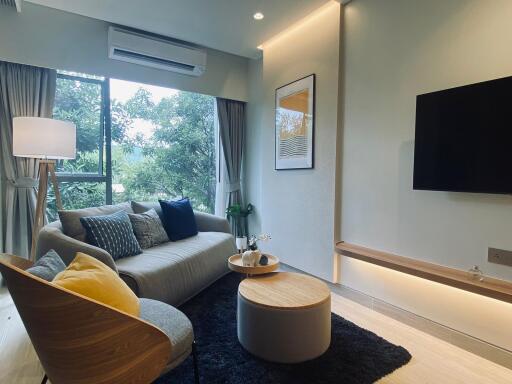 Modern living room with sofa, chairs, and wall-mounted TV