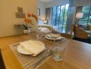 Dining area near living space with table setting and view of the patio