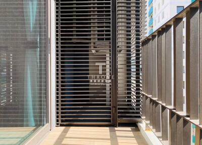 Sunny, modern balcony with metal railings and privacy screen