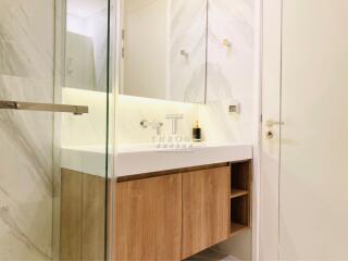 Modern bathroom with wooden cabinets and marble accents