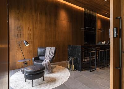 Modern living room with black leather furniture and wooden paneling