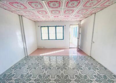 A spacious bedroom with uniquely patterned ceiling and tiled flooring
