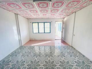 A spacious bedroom with uniquely patterned ceiling and tiled flooring