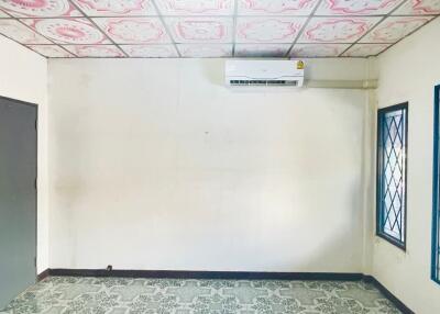 Empty bedroom with air conditioner and decorative ceiling tiles