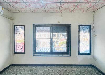 Empty room with three windows and patterned floor tiles