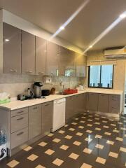 Modern kitchen with brown and beige cabinetry and ample lighting