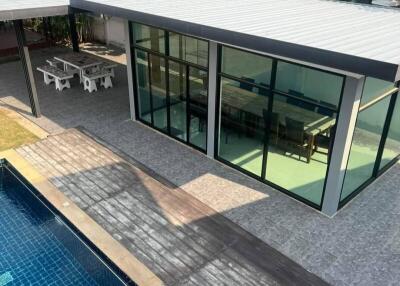 Outdoor area with pool, dining space, and modern glass building