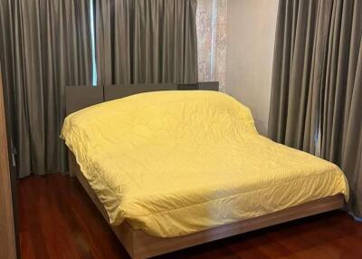 Bedroom with wooden flooring and curtains