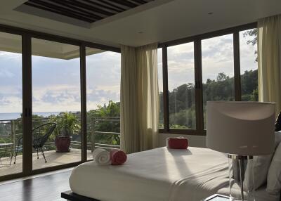 Spacious bedroom with large windows and balcony view