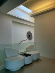 Stylish modern sitting area with unique circular chairs and decorative wall art