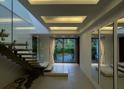 Modern hallway with illuminated ceiling and glass staircase