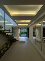 Modern hallway with illuminated ceiling and glass staircase