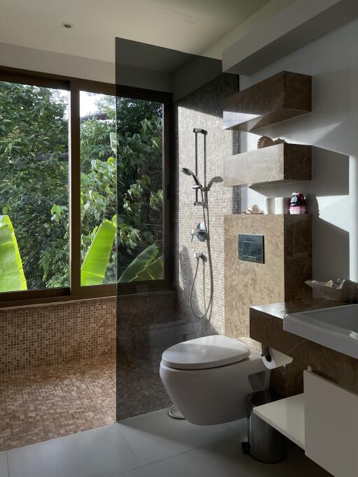 Modern bathroom with a large window, glass shower, and elegant fixtures