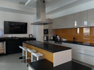 Modern kitchen with island, bar stools, and stainless steel appliances