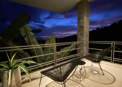 Balcony with chairs and a table at dusk with scenic view