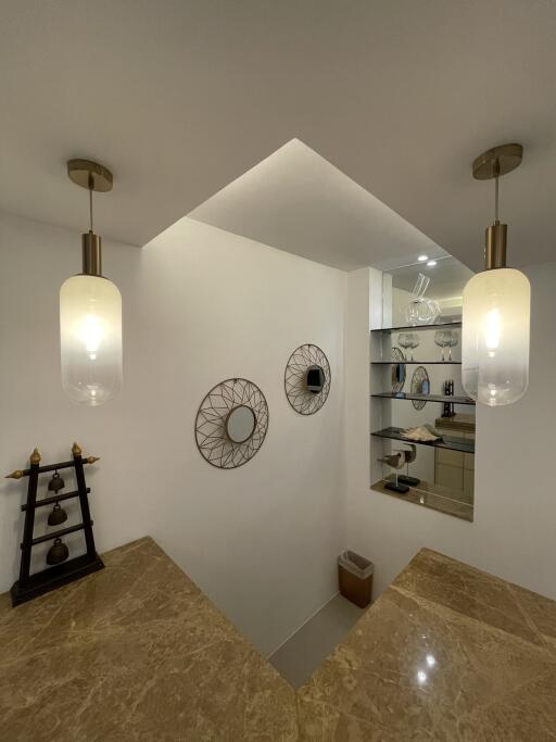 Staircase area with hanging lights and decorative wall mirrors