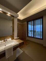 Modern bathroom with vanity, a large mirror, and a view through blinds.