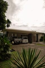 Front view of a modern house with covered driveway and parked cars