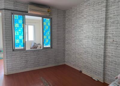 Unfurnished bedroom with brick-patterned wallpaper and wooden flooring